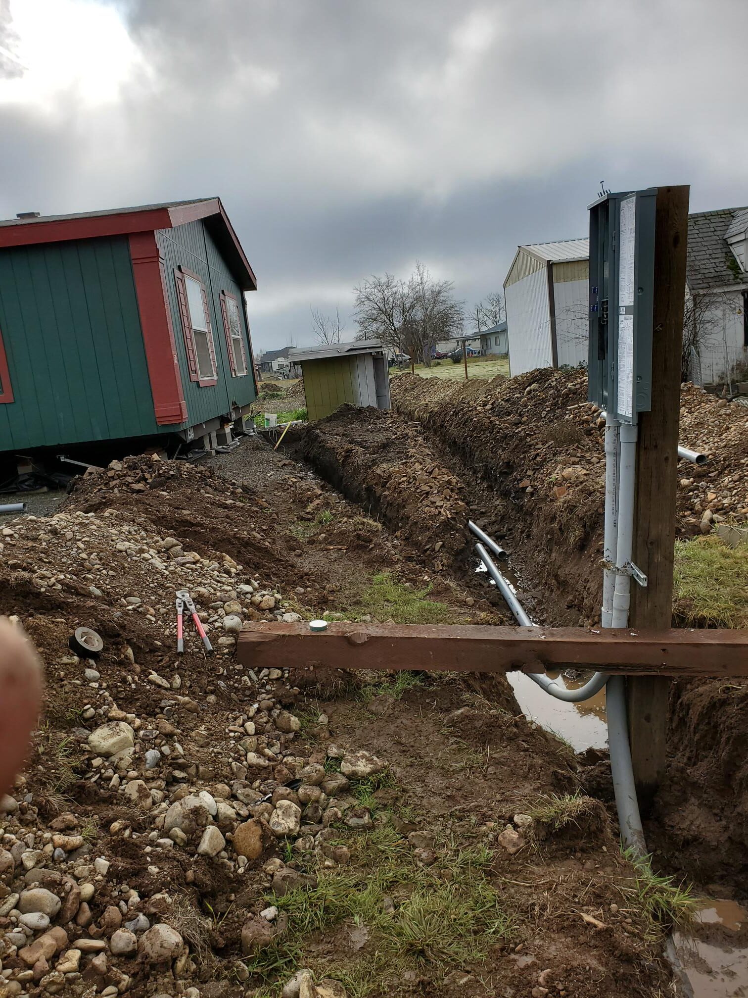 Underground electrical conduit trench beside a building
