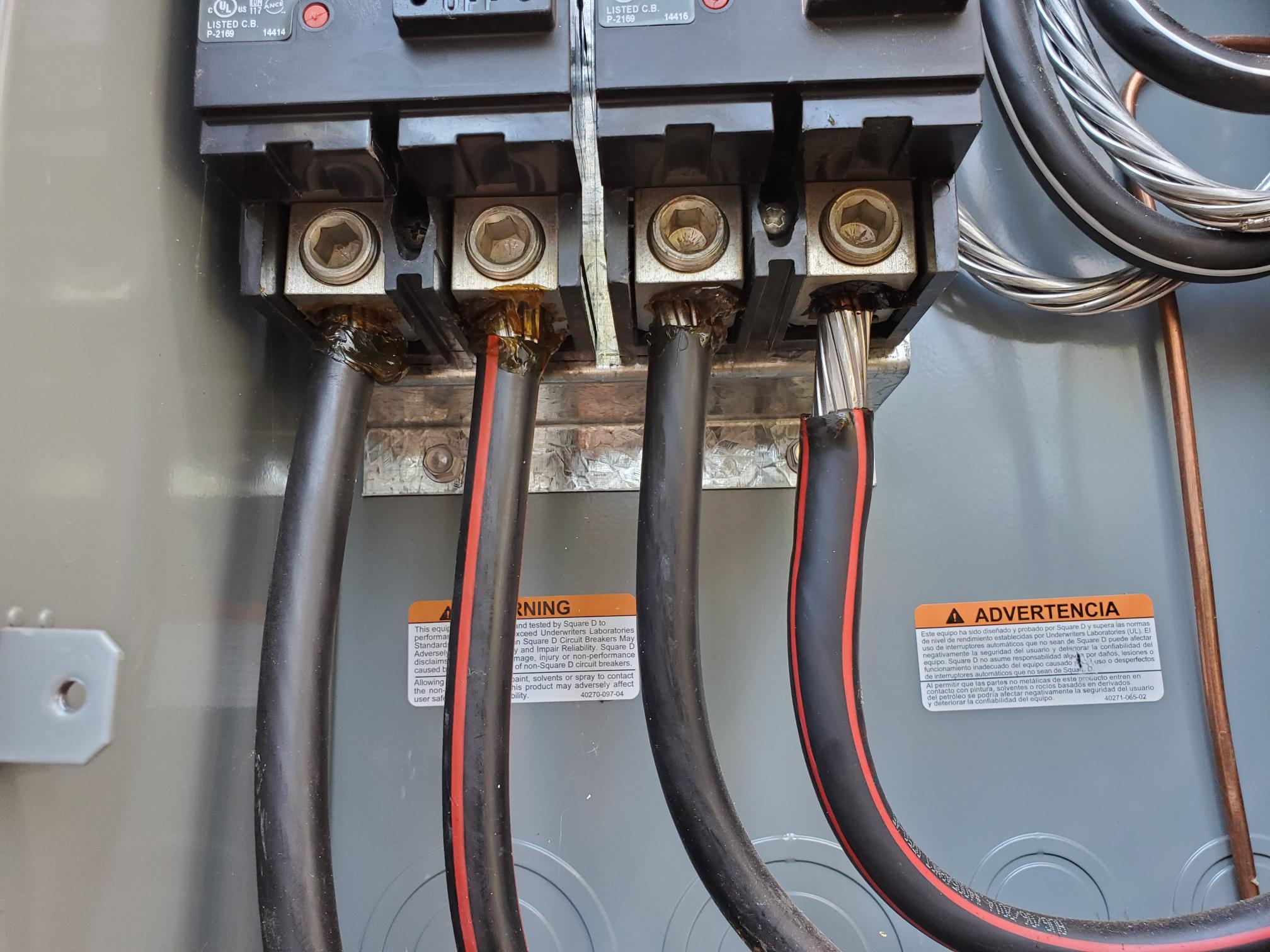 Close-up of heavy electrical service conductors terminated in equipment
