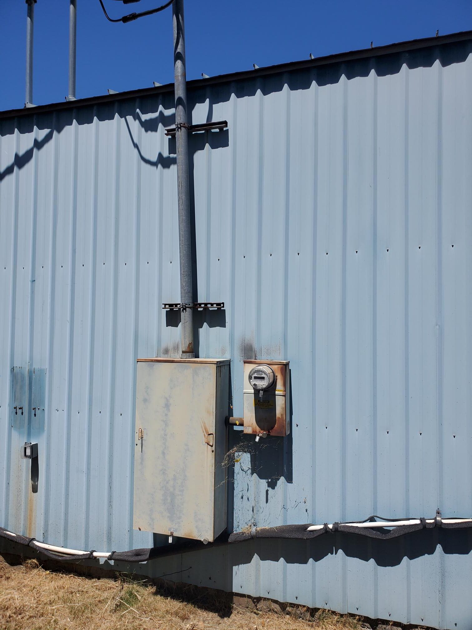 Weatherproof outdoor electrical equipment mounted on a metal building