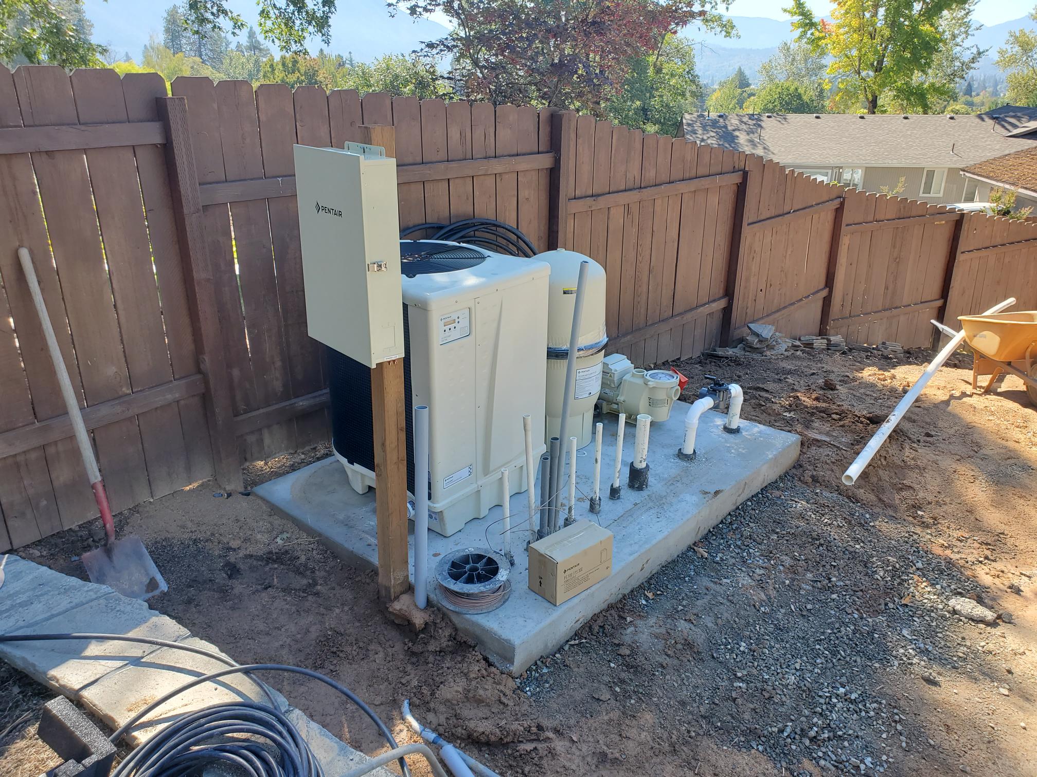 Outdoor electrical equipment and conduit installed beside a fence