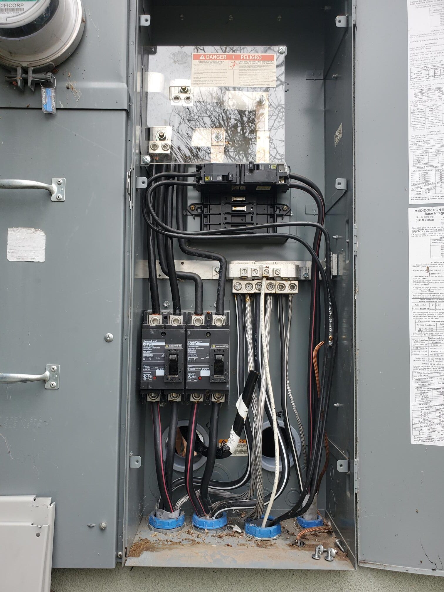Open electrical panel showing breakers and service conductors